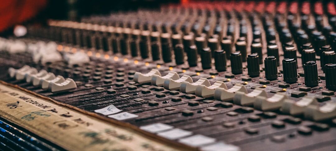 Hands on a professional audio mixing console in a recording studio