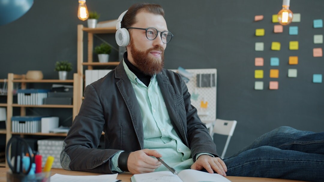 Person wearing headphones listening and taking notes